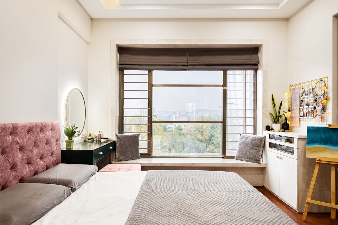 A cozy bedroom with a large window and city view.