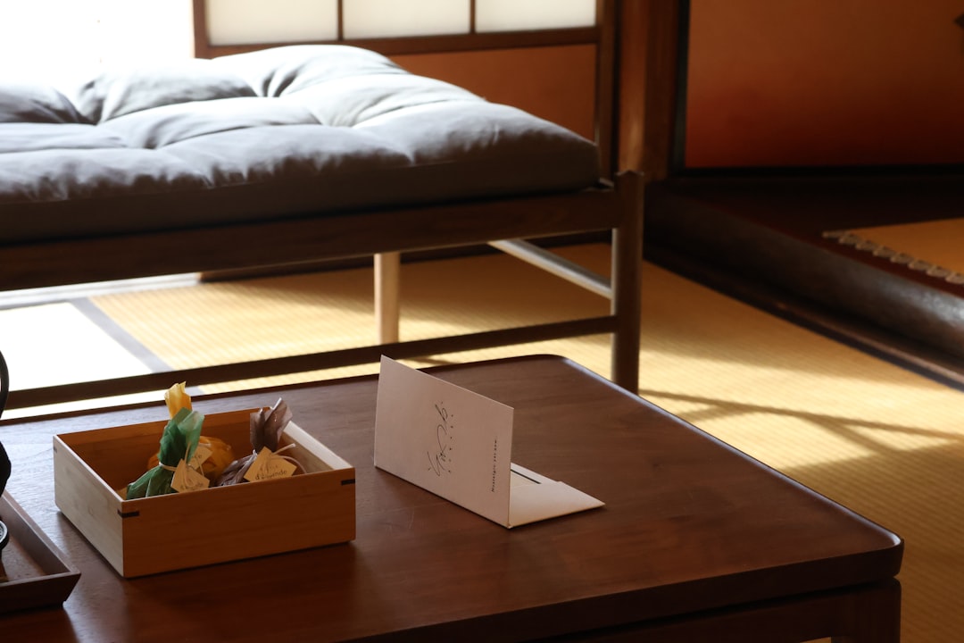 A room with a bed and a table with a box of food on it
