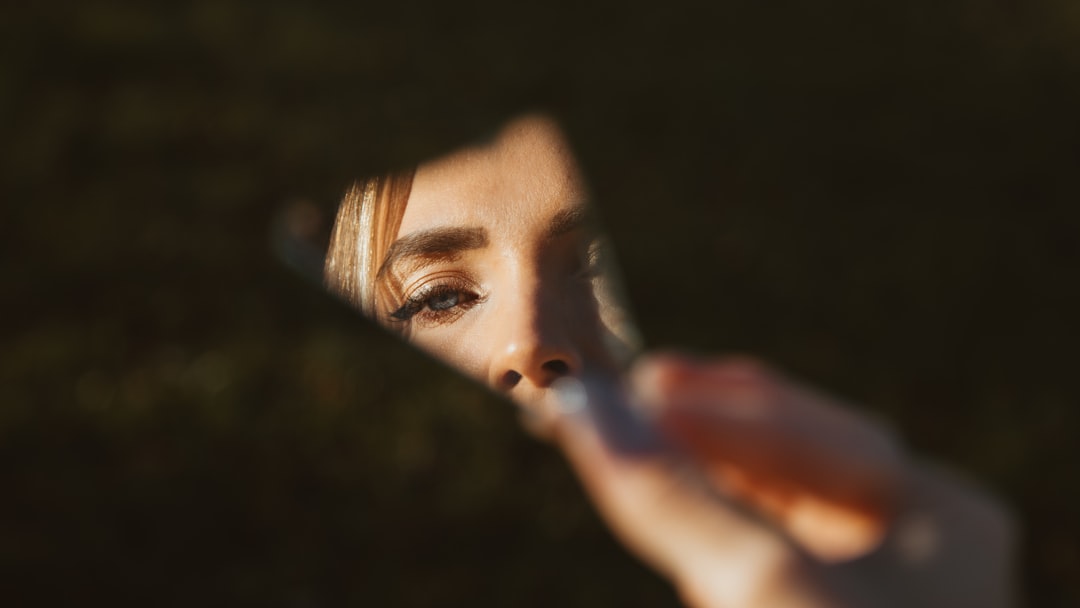 A woman holding a toothbrush in front of her face