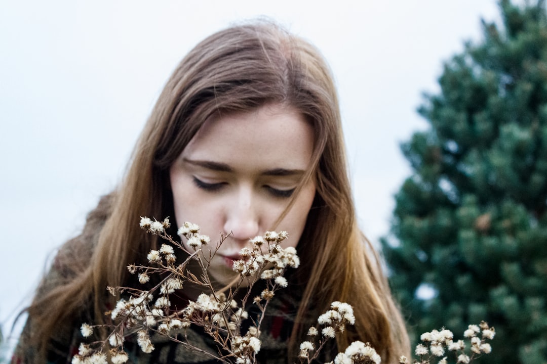 a woman holding a bunch of flowers in front of her face