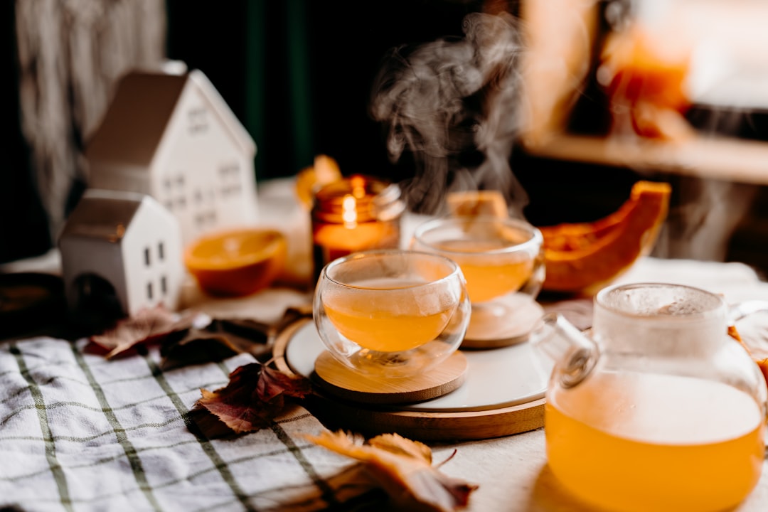 Steaming hot tea served in clear glasses with autumn decor.