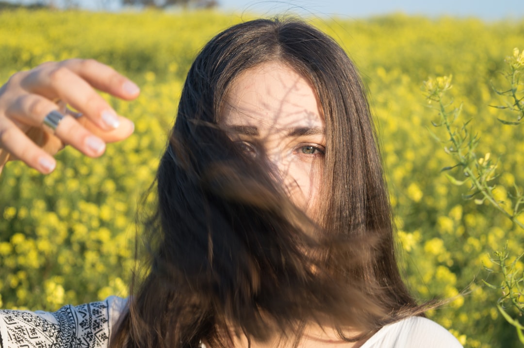 woman wearing white shirt covering face with her hair