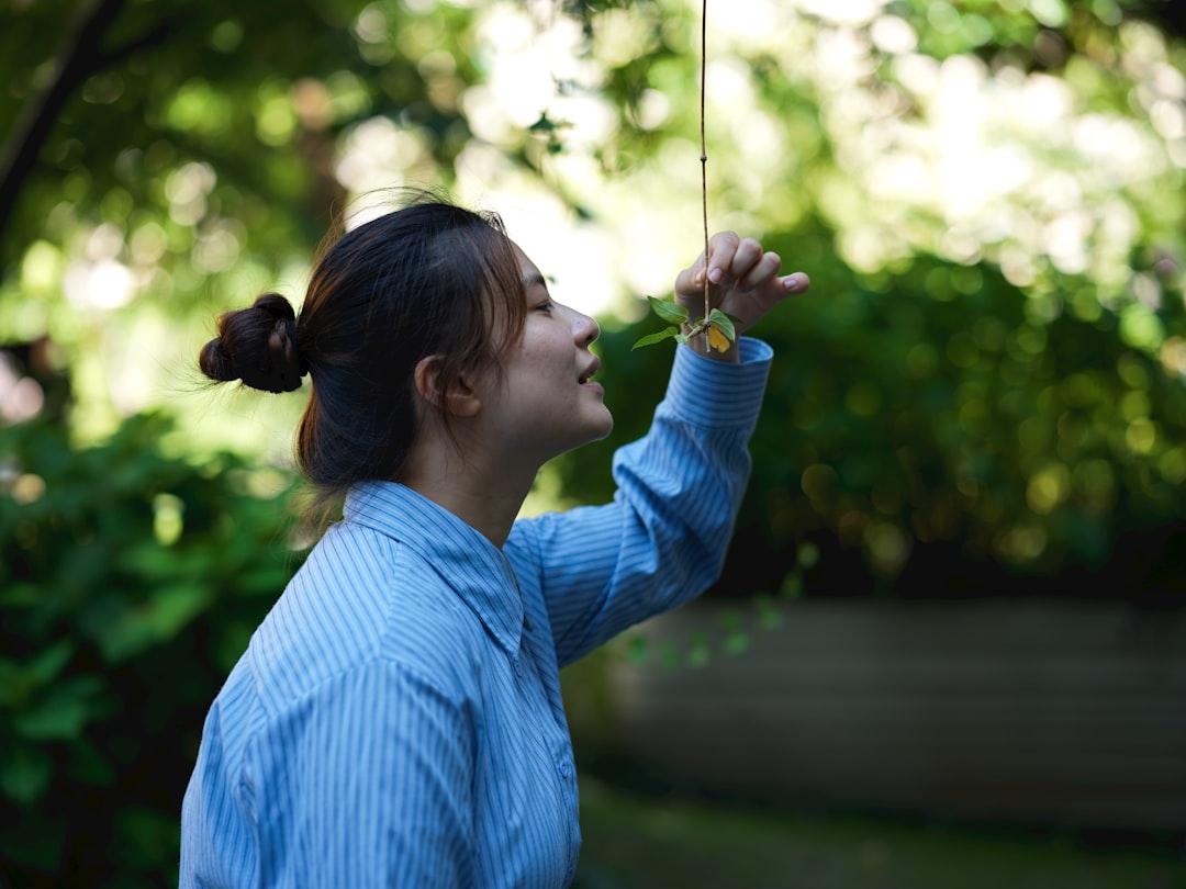 A woman in a blue shirt is holding an umbrella