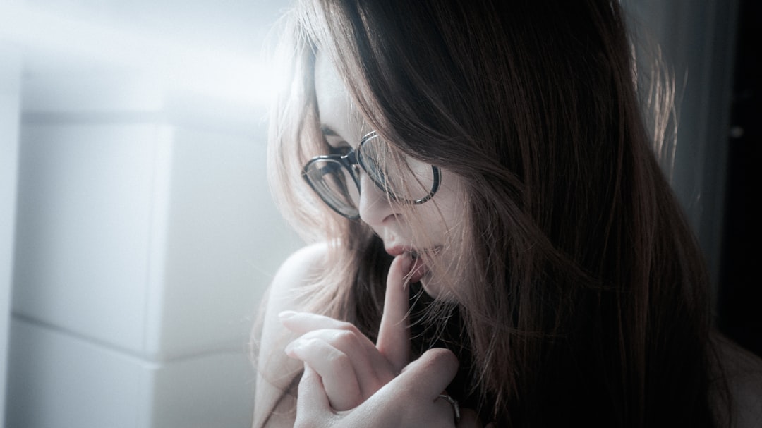 A young woman with glasses looking down