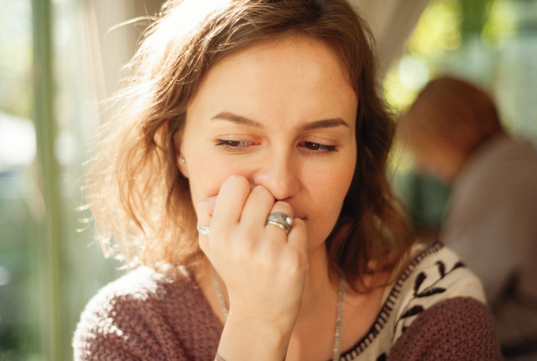 a woman holding her nose to her nose