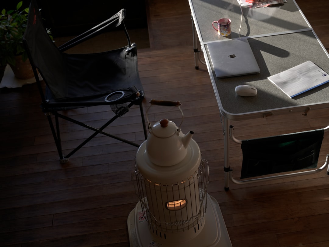 Camp chair and table with laptop and heater.