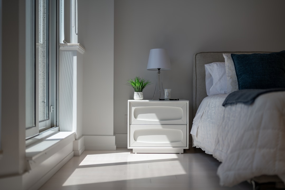 Sunlight illuminates a cozy bedroom with a bed and nightstand.