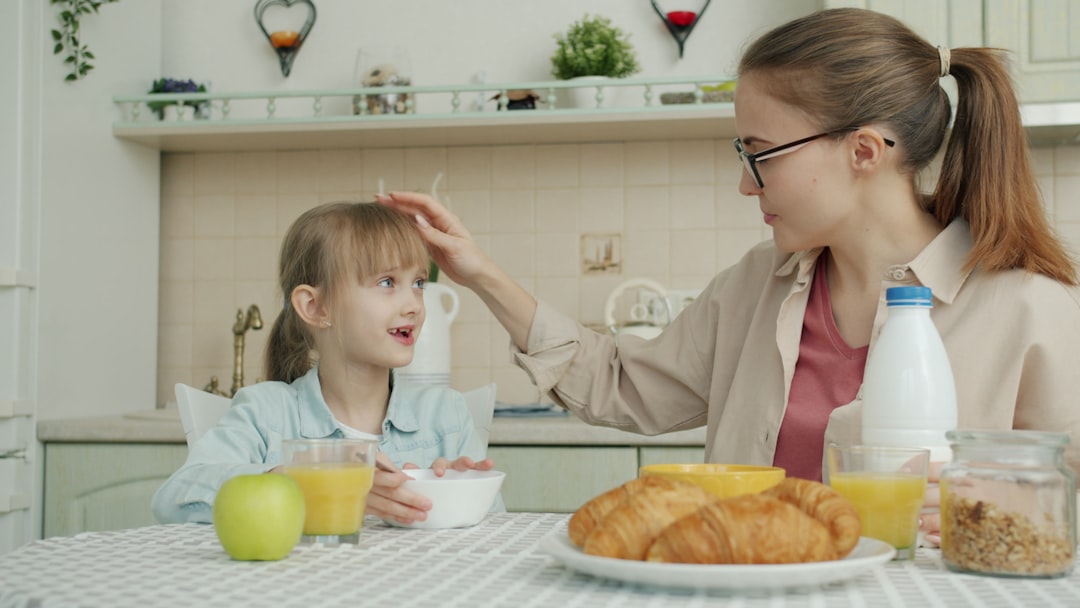 Mother touches daughter's hair during breakfast