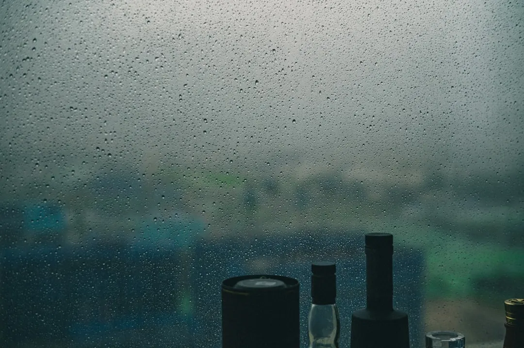 A couple of bottles sitting on top of a window sill